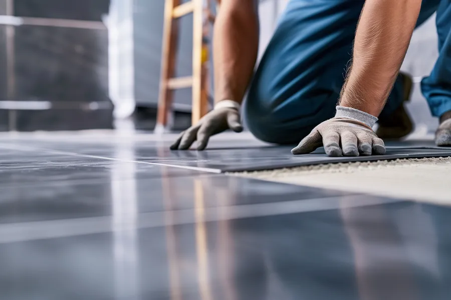 Graue Fliesen werden verlegt.